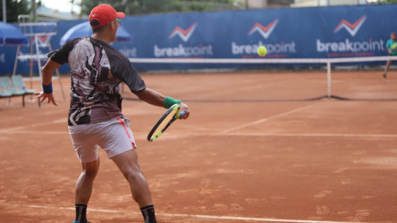 male tennis player hitting tennis in front of breakpoint banner