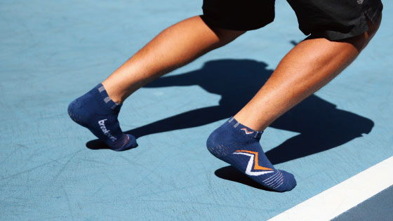 male wears breakpoint tennis socks on tennis court