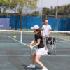 tennis coach and a female student hitting the ball.